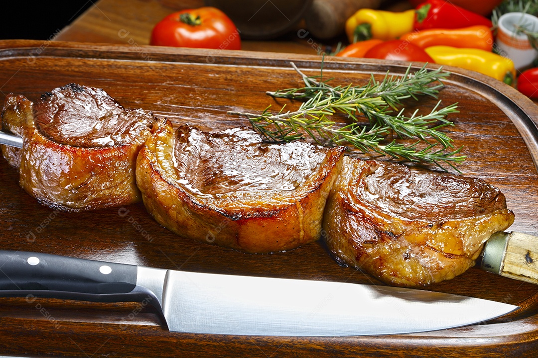 Picanha assada no espeto sobre tábua de madeira