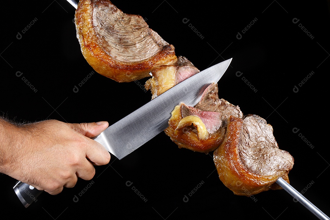 Espeto de picanha assado com mão cortando