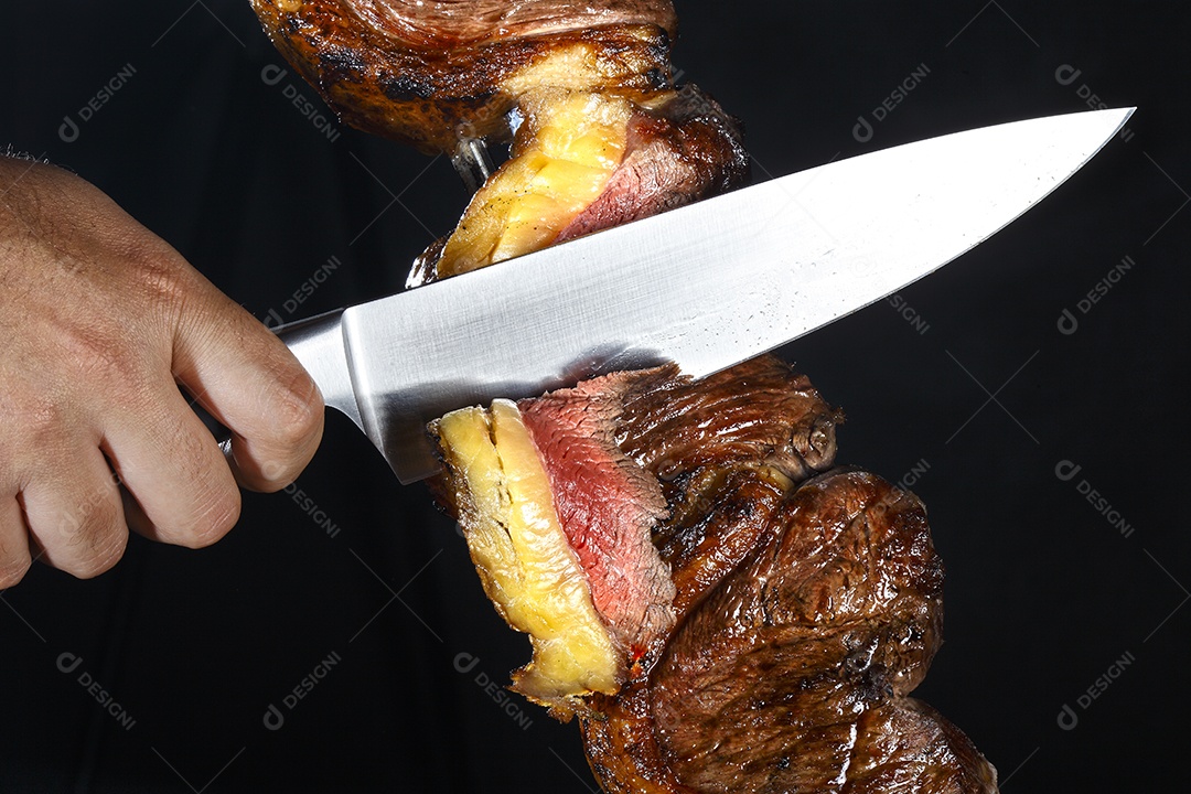 Espeto de picanha assado mão cortando