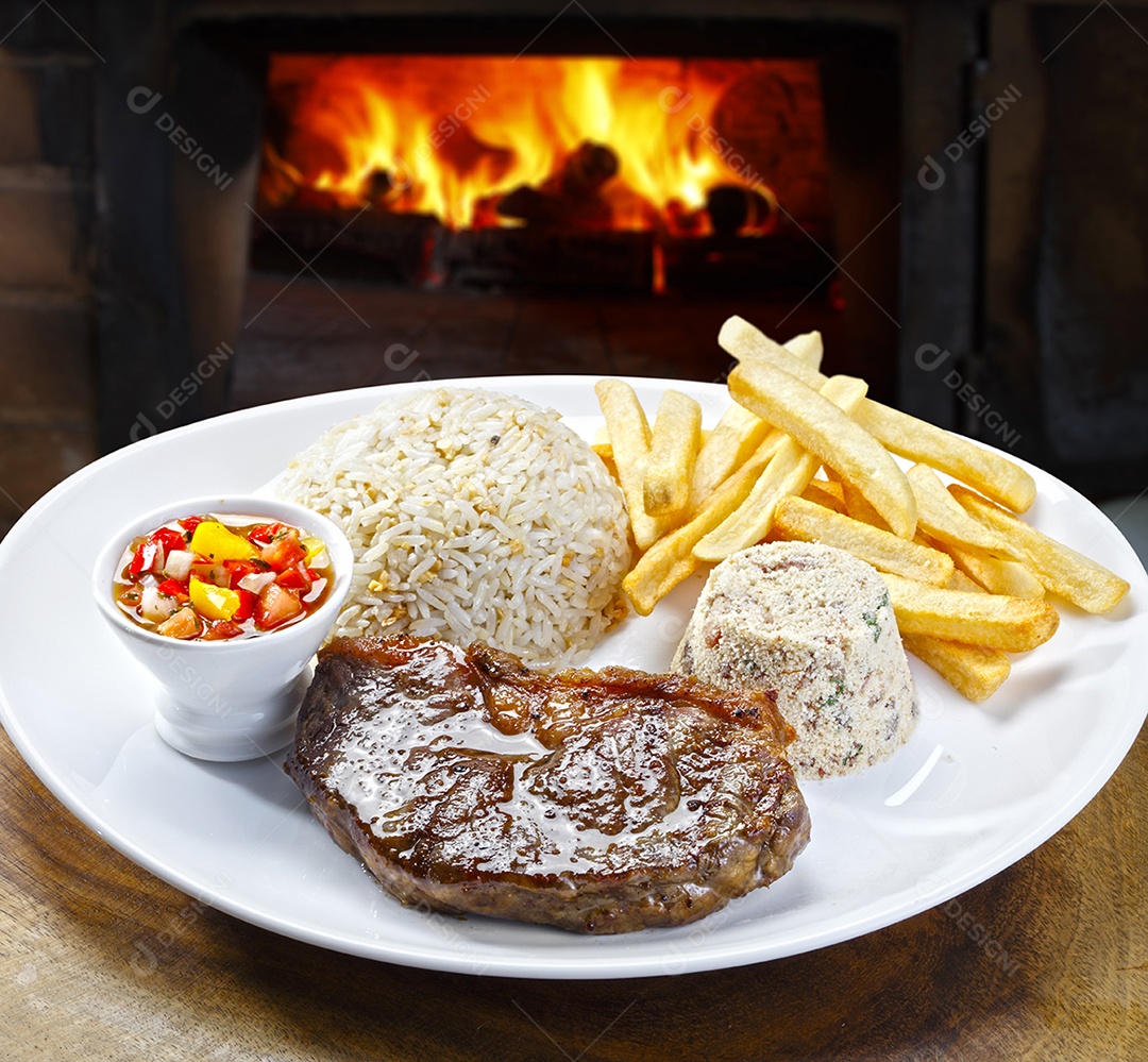 Comida tradicional vinagrete batatas fritas farofa arroz e carne grelhada