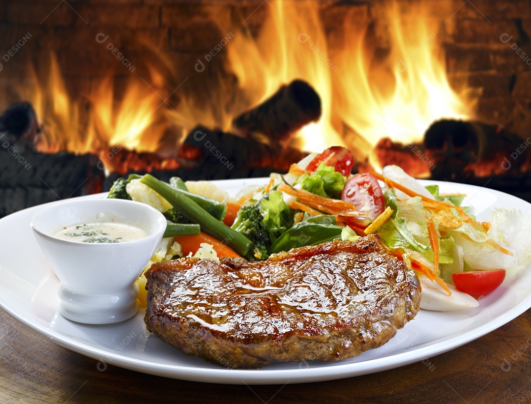 Bife de carne assada com salada e molho