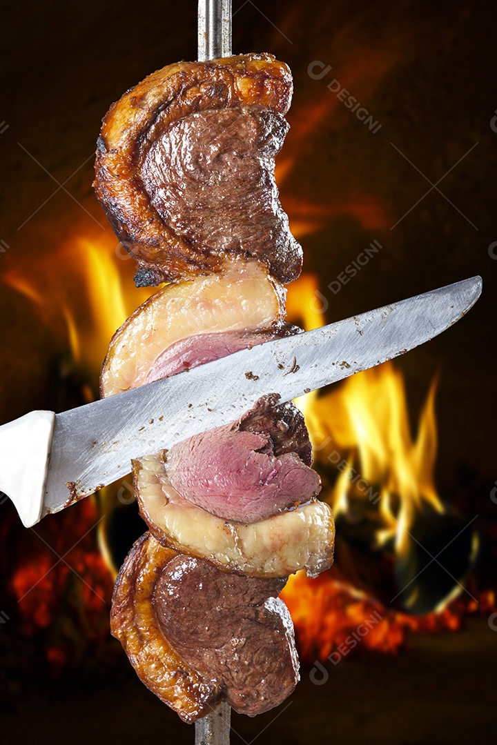 Espeto de picanha asssado com mãos cortando