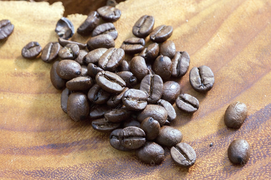 Grãos de café em uma tigela sobre uma mesa de madeira