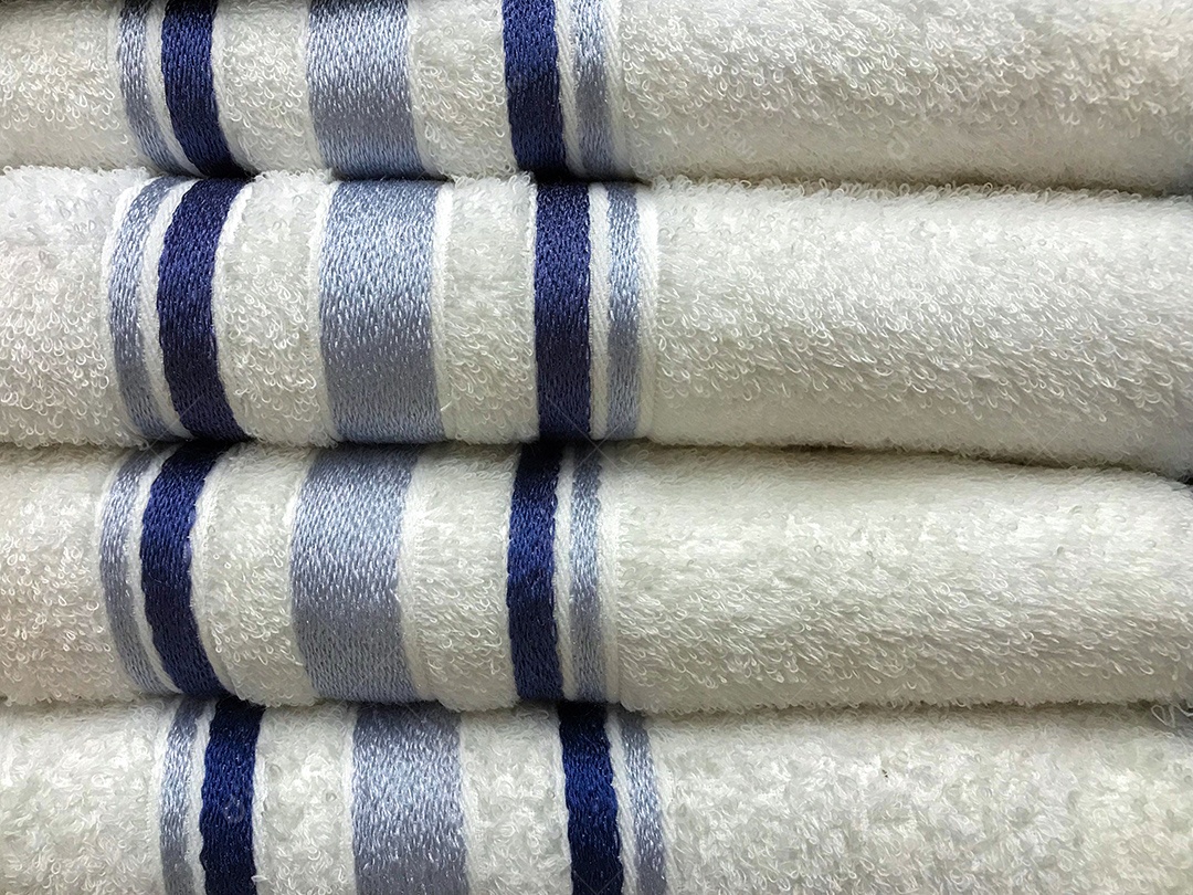Pilha de toalhas limpas e macias brancas com linhas azuis