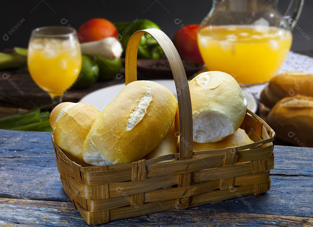 Cesta com pão francês sobre uma mesa de madeira