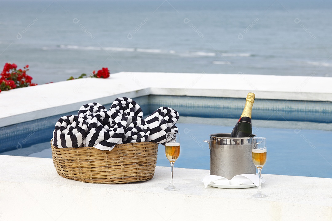 Champanhe na piscina com cesta e toalhas dentro