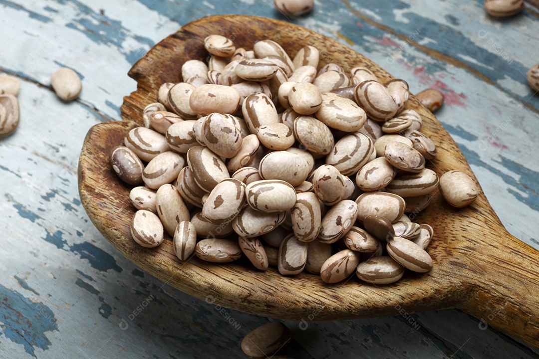 Grãos de feijão sobre colher de madeira