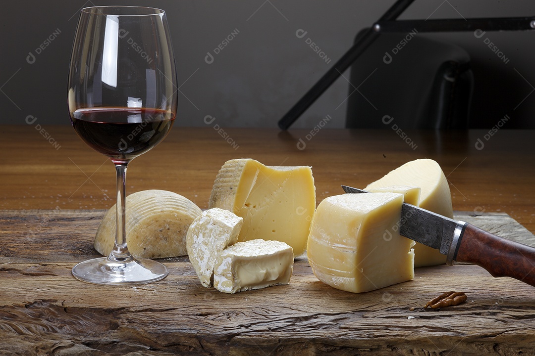 Taça de vinho com queijos ao lado