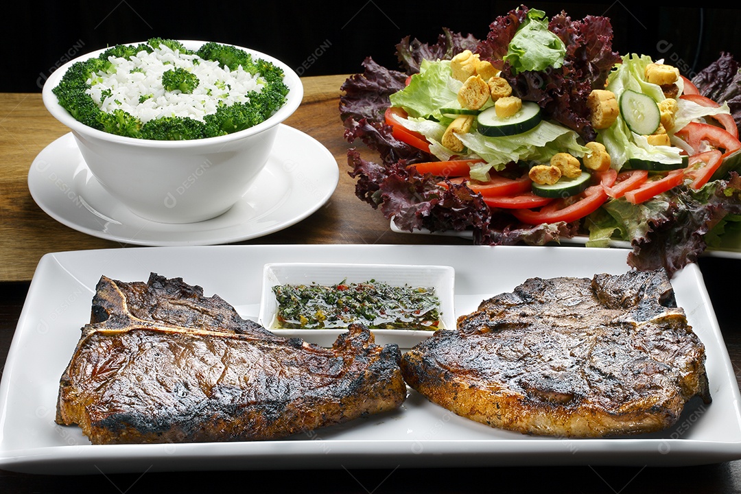 T bone assado com arroz salada e molhos