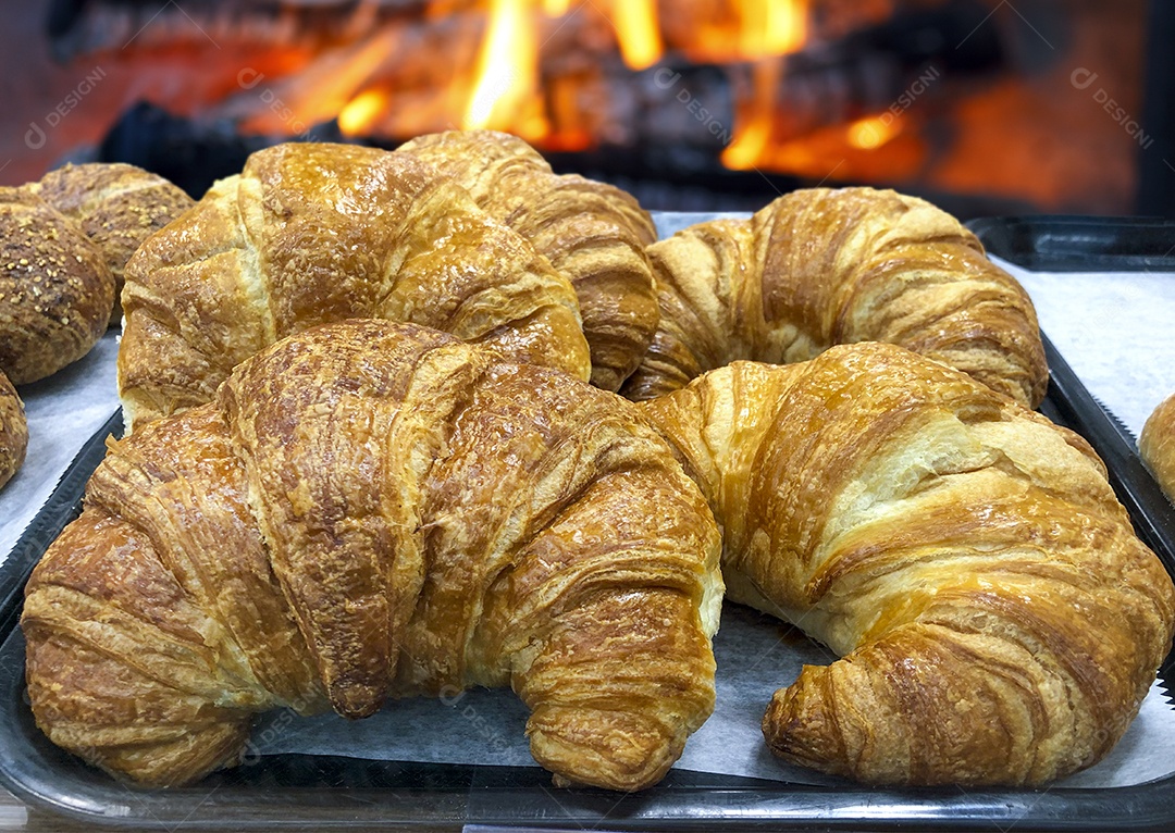 Croissants sobre bandeja com papel manteiga