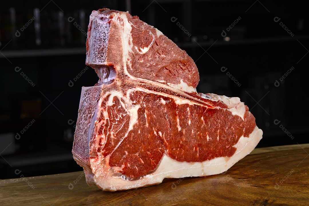 T bone crua sobre uma mesa de madeira