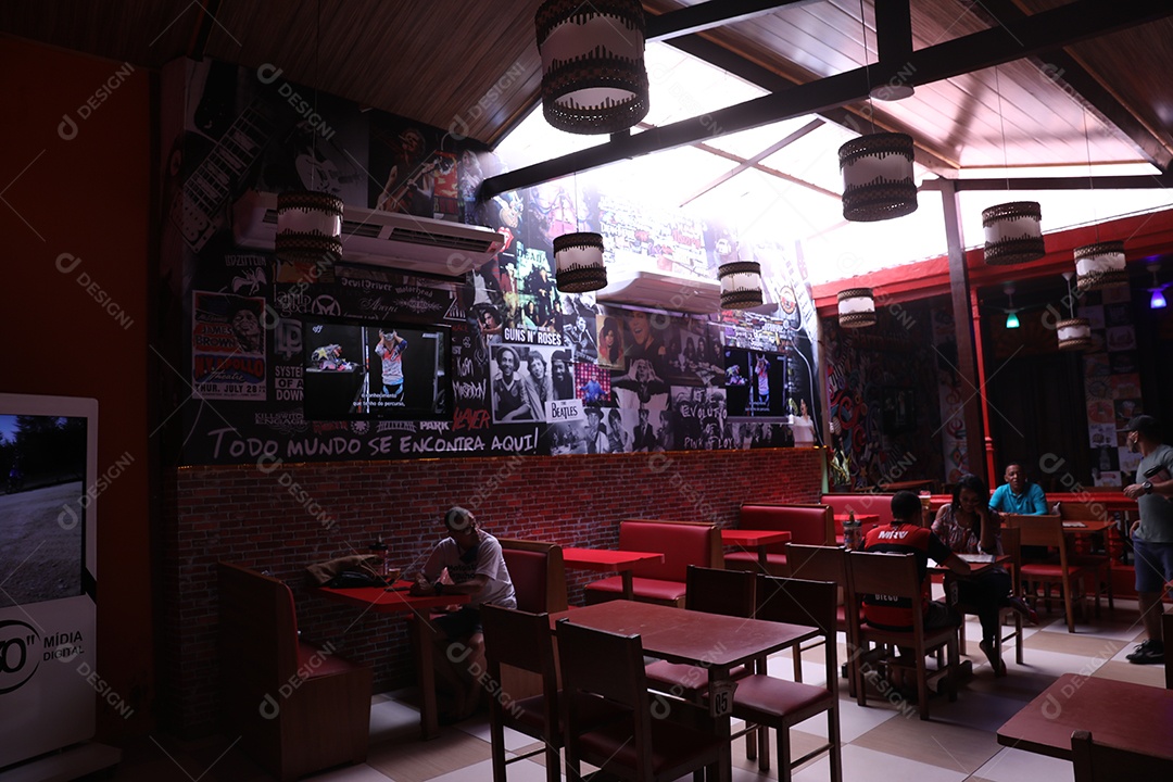 Estabelecimento com pessoas sentadas sobre uma cadeira