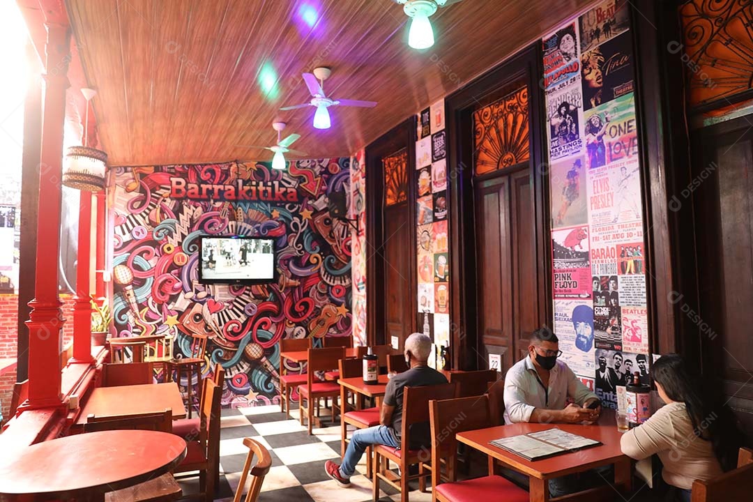 Estabelecimento com pessoas sentadas sobre uma cadeira