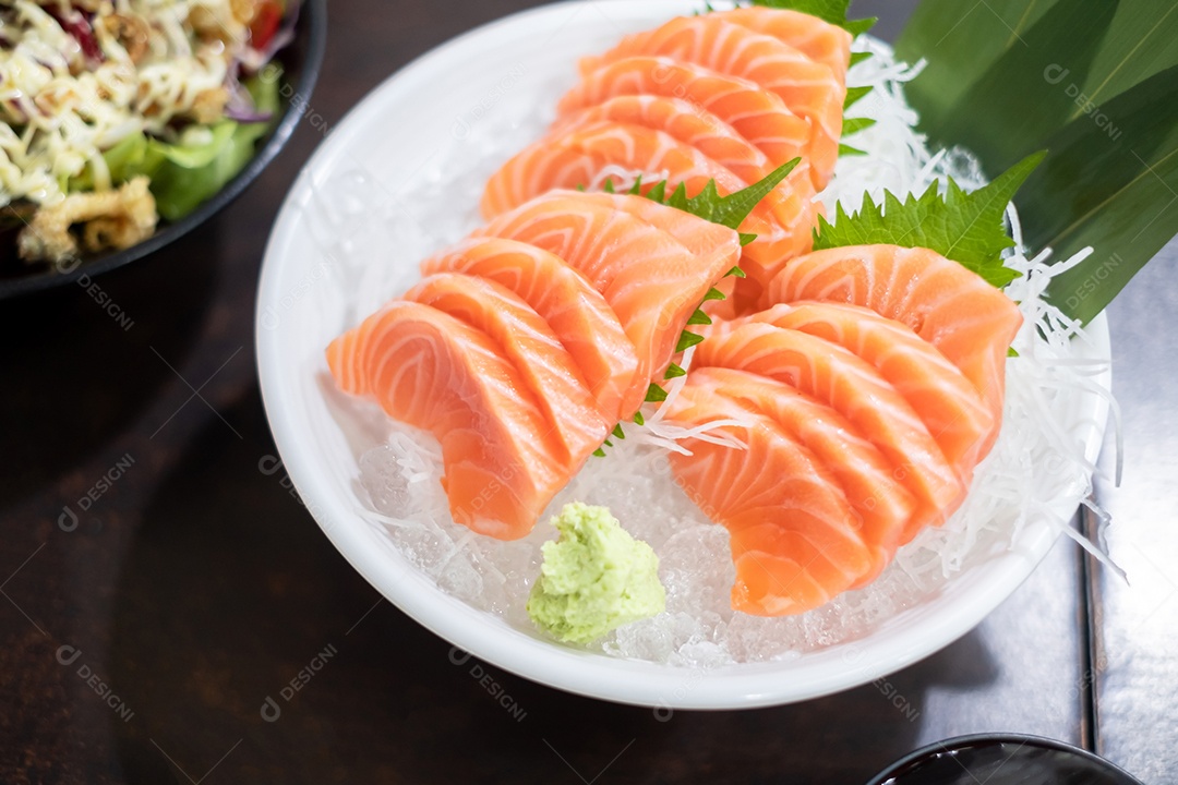 Salmão fatiado fresco ou sashimi de salmão com tigela branca colocada na mesa