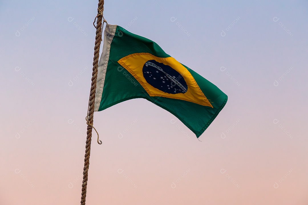 bandeira do brasil ao ar livre com um lindo céu colorido do pôr do sol no Rio de Janeiro