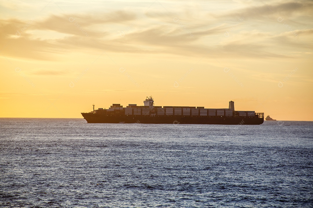 silhueta de um navio cargueiro ao amanhecer na praia de copacabana, no rio de janeiro