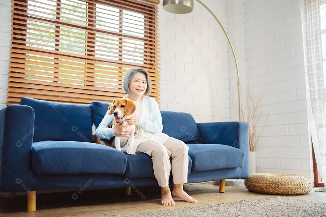 Mulher asiática sênior desfrutando de seu cão de estimação correndo em casa