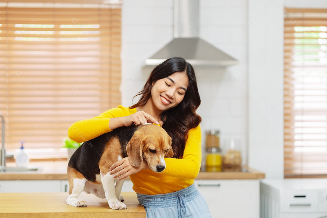 Mulher asiática feliz desfrutando de seu cão de estimação em casa