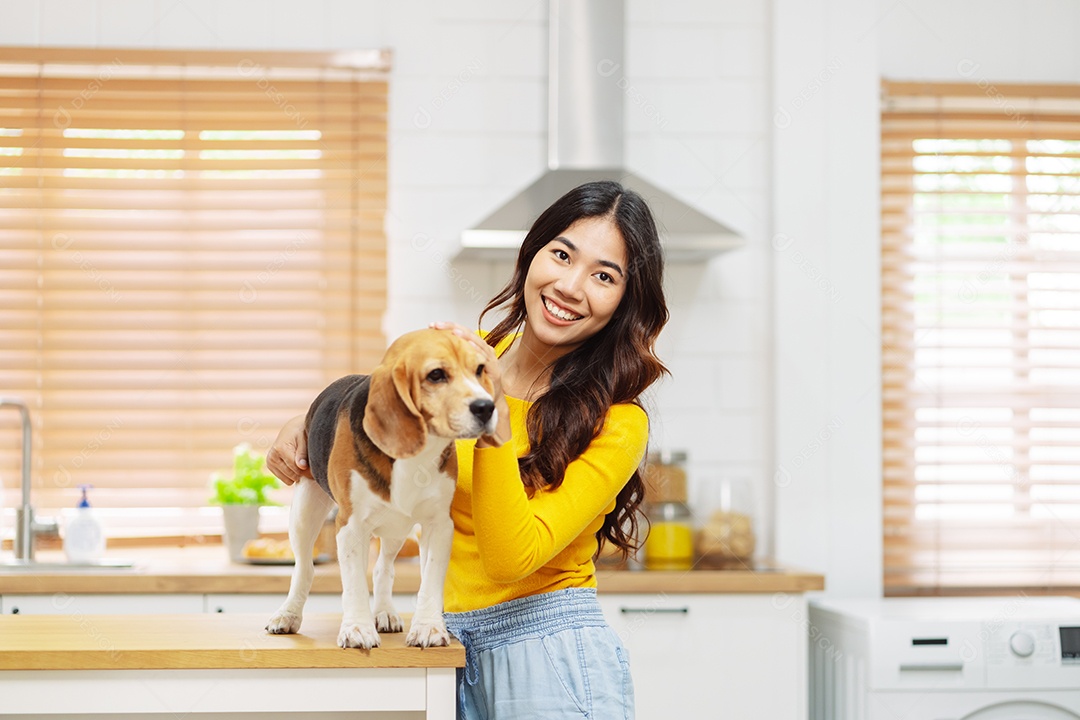 Mulher asiática feliz desfrutando de seu cão de estimação em casa