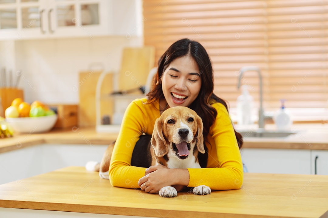 Mulher asiática feliz desfrutando de seu cão de estimação em casa