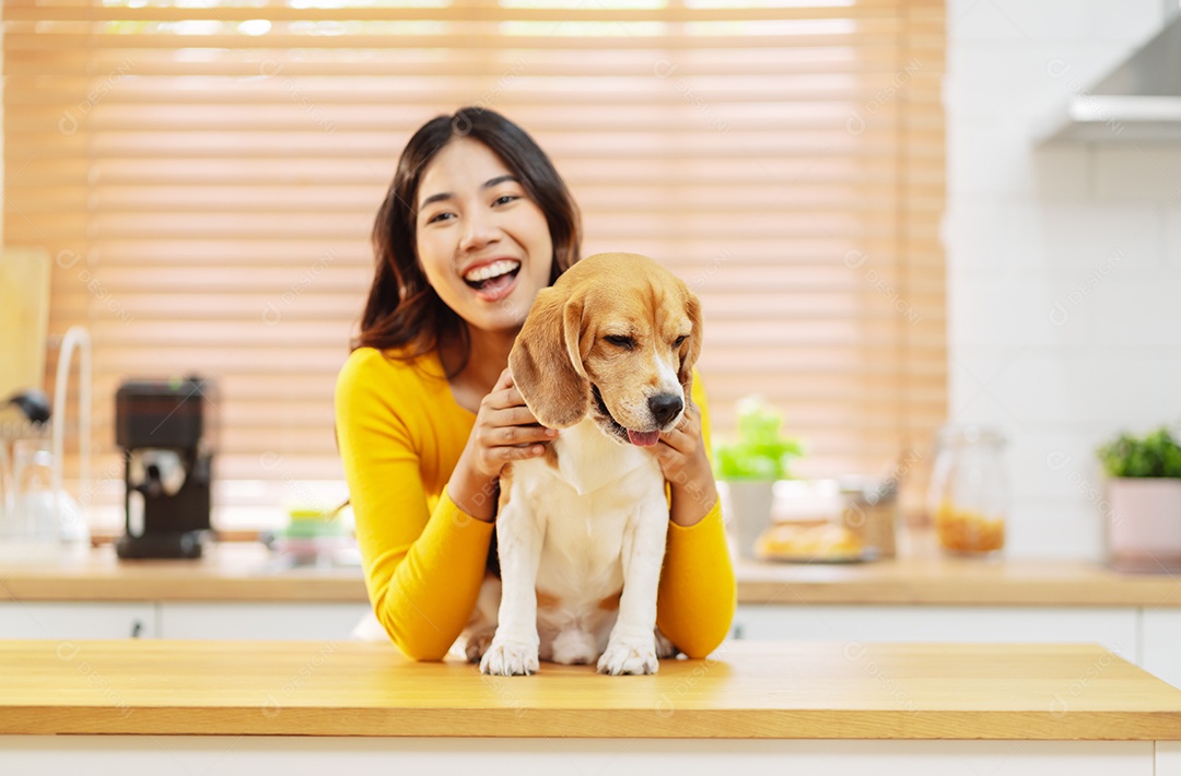 Mulher asiática feliz desfrutando de seu cão de estimação em casa