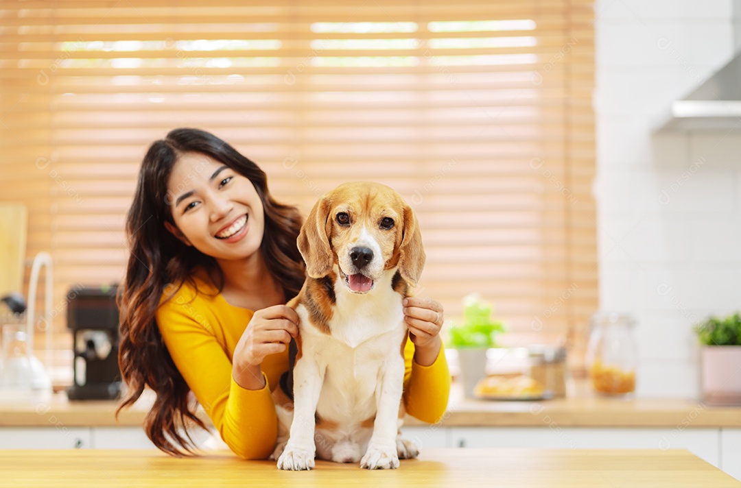 Mulher asiática feliz desfrutando de seu cão de estimação em casa