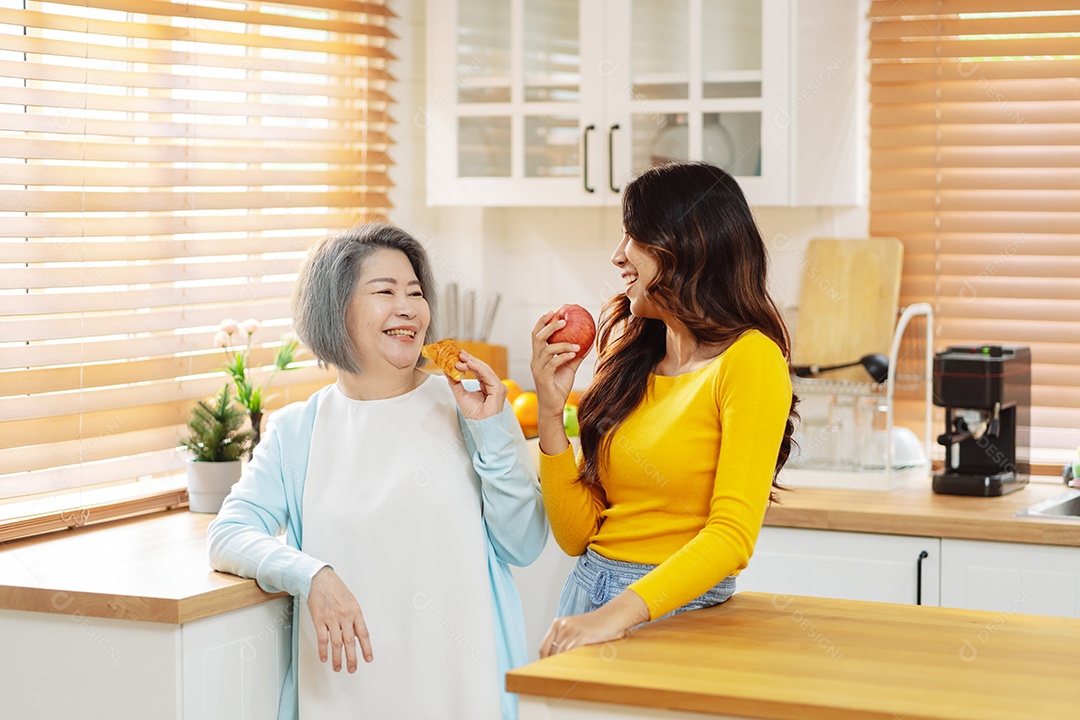 Mãe filha asiáticas se alimentando na cozinha