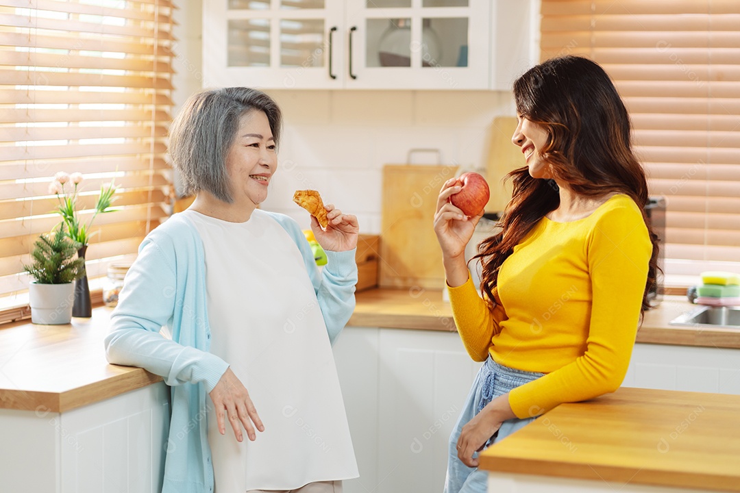 Mulher sênior e filha felizes na cozinha