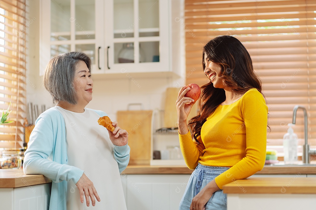 Mulher sênior e filha felizes na cozinha