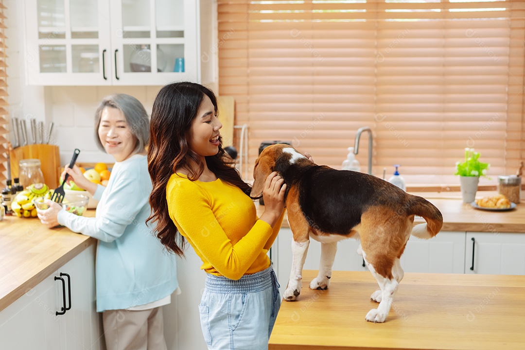 Mulher asiática sênior e filha desfrutando de seu animal de estimação em casa