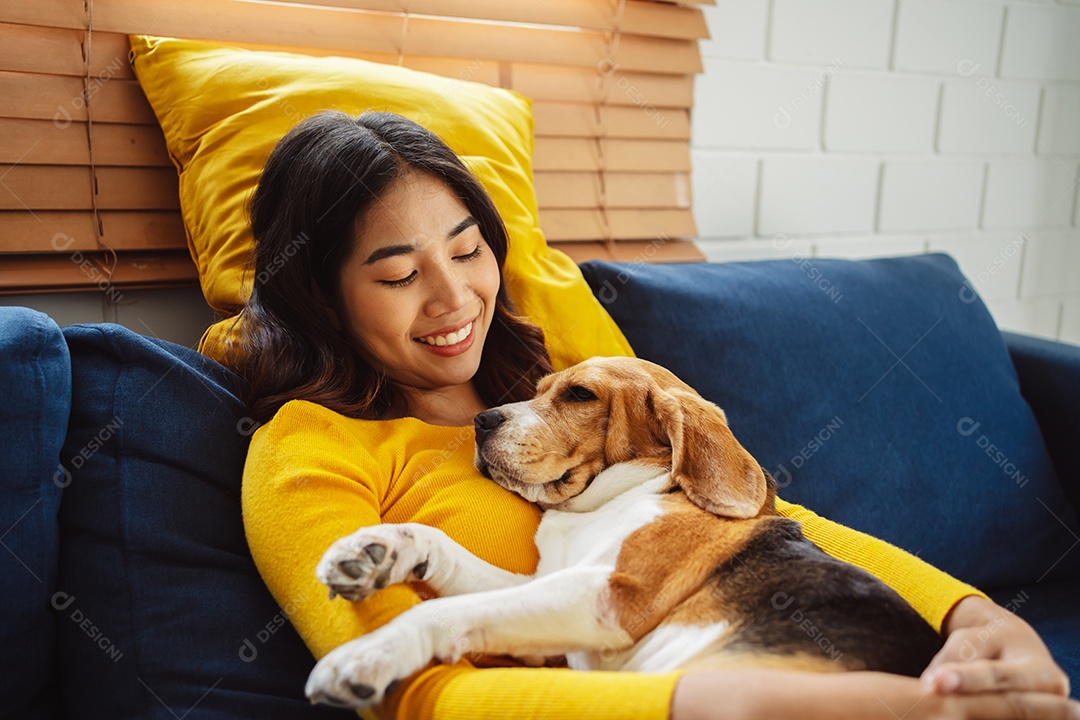 Mulher asiática feliz desfrutando de seu cão de estimação em casa