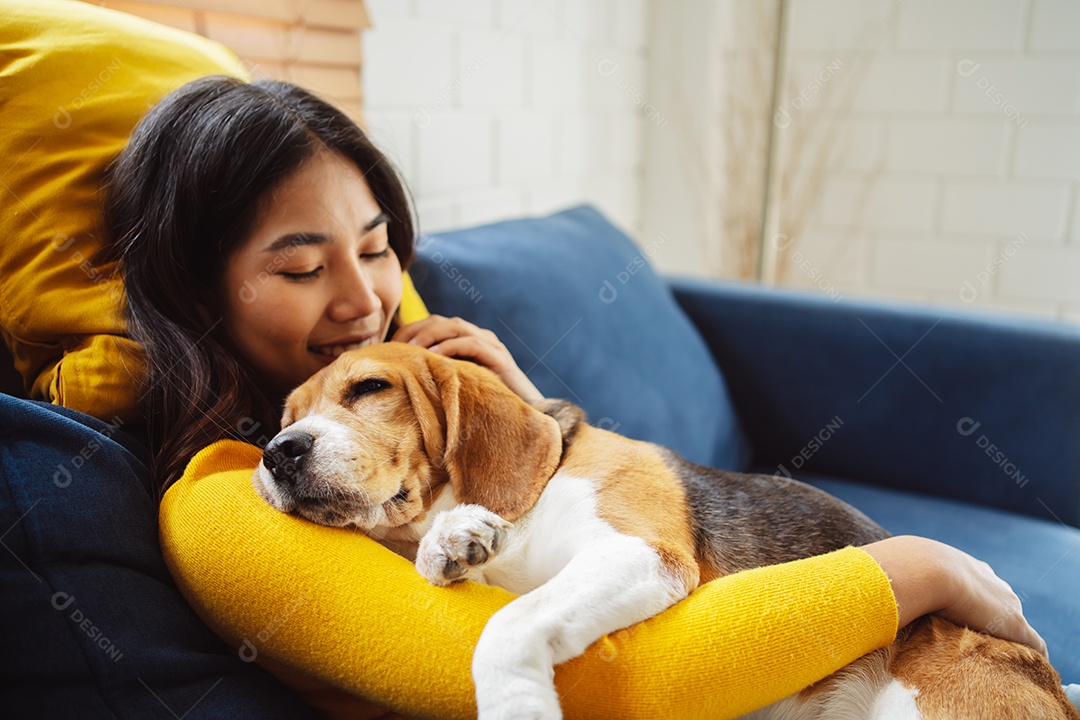 Mulher asiática feliz desfrutando de seu cão de estimação em casa
