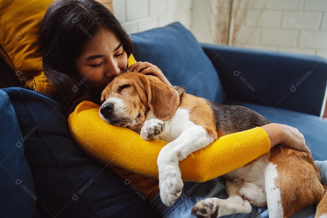 Mulher asiática feliz desfrutando de seu cão de estimação em casa