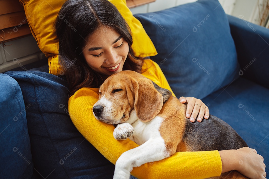 Mulher asiática feliz desfrutando de seu cão de estimação em casa