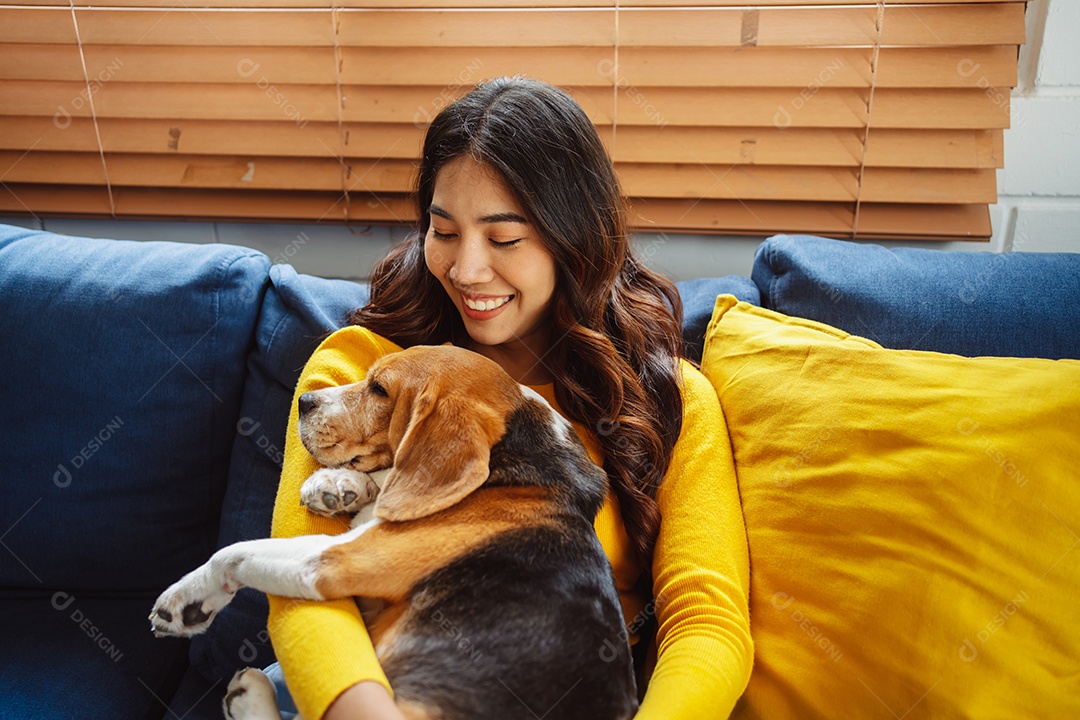 Mulher asiática feliz desfrutando de seu cão de estimação em casa