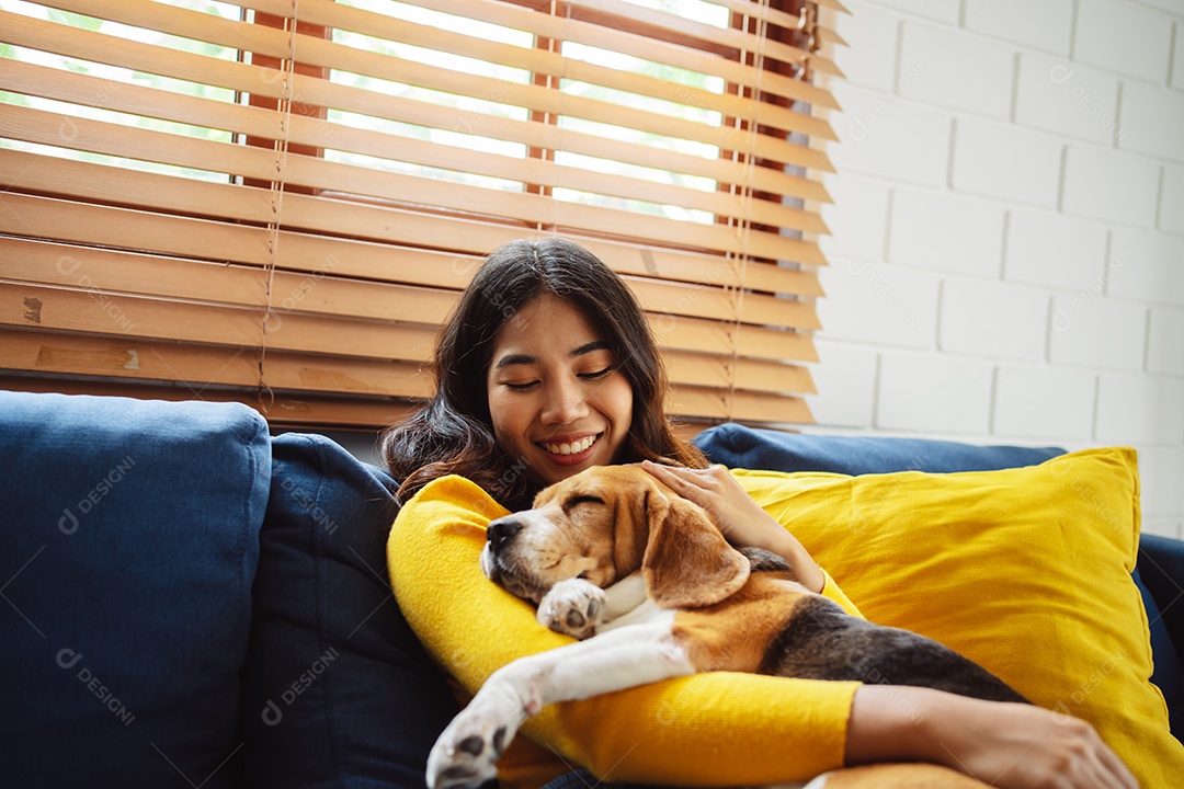 Mulher asiática feliz desfrutando de seu cão de estimação em casa