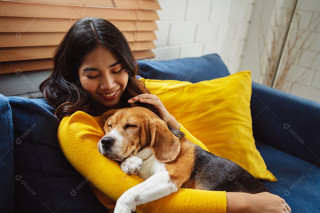 Mulher asiática feliz desfrutando de seu cão de estimação em casa