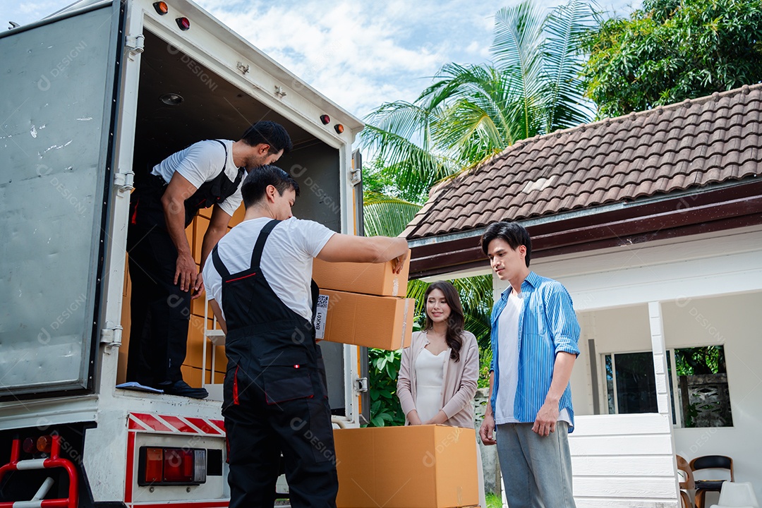 Verificação de casal asiático ao descarregar caixas e móveis de uma caminhonete para uma nova casa