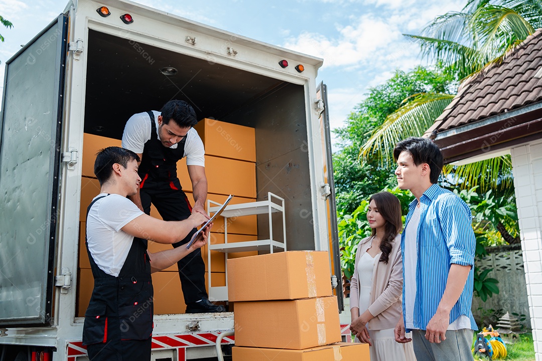 Verificação de casal asiático ao descarregar caixas e móveis de uma caminhonete para uma nova casa