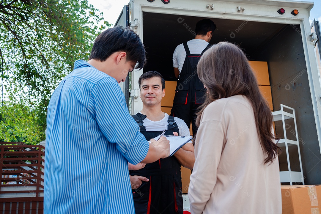 Verificação de casal asiático ao descarregar caixas e móveis de uma caminhonete para uma nova casa