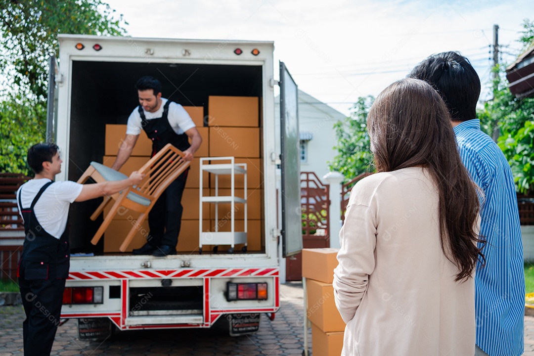 Verificação de casal asiático ao descarregar caixas e móveis de uma caminhonete para uma nova casa