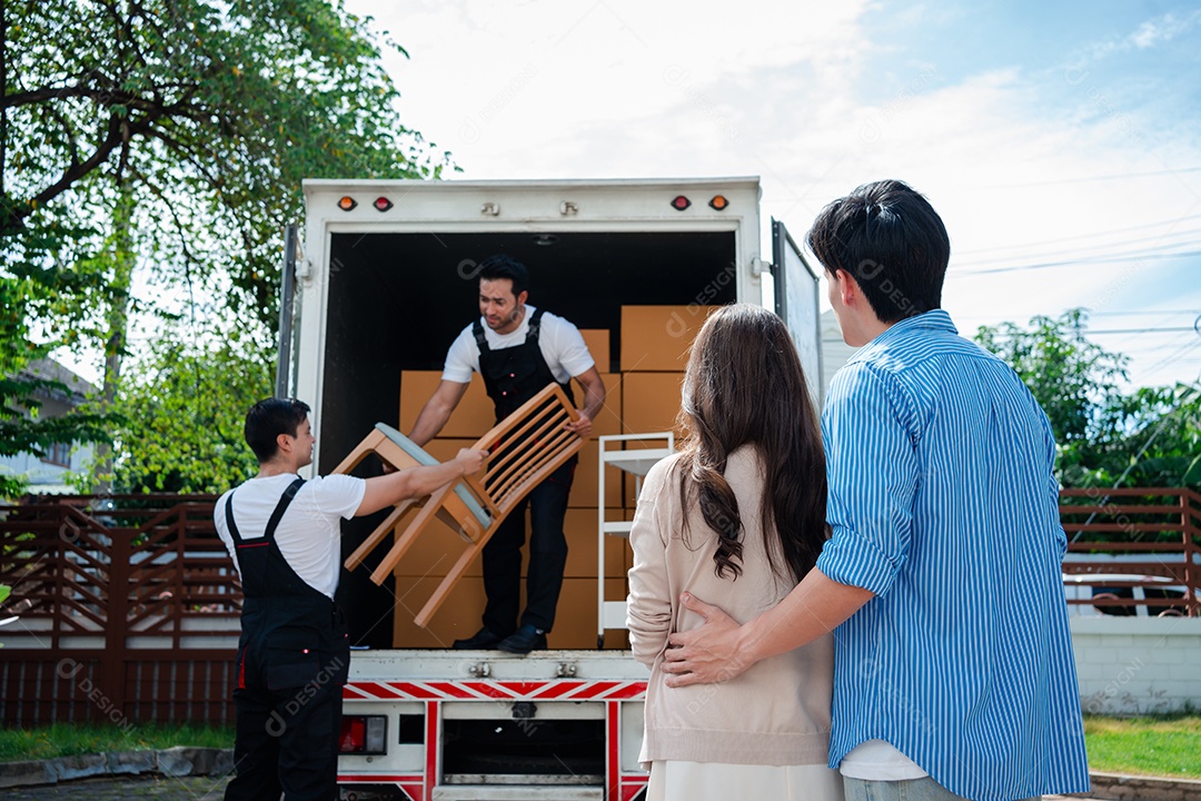 Verificação de casal asiático ao descarregar caixas e móveis de uma caminhonete para uma nova casa