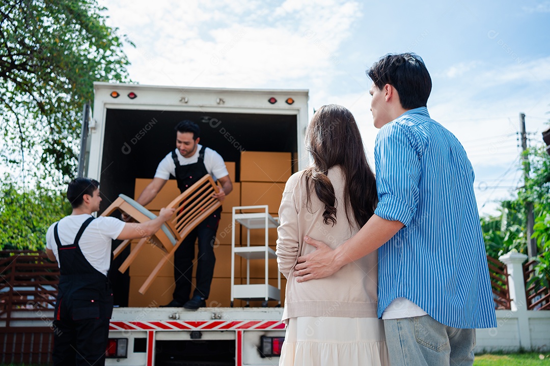 Verificação de casal asiático ao descarregar caixas e móveis de uma caminhonete para uma nova casa