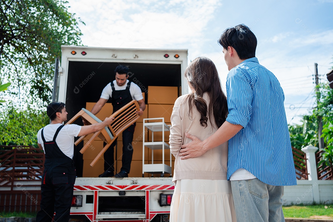 Verificação de casal asiático ao descarregar caixas e móveis de uma caminhonete para uma nova casa