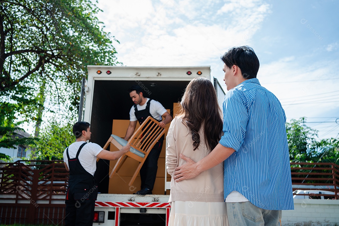 Verificação de casal asiático ao descarregar caixas e móveis de uma caminhonete para uma nova casa
