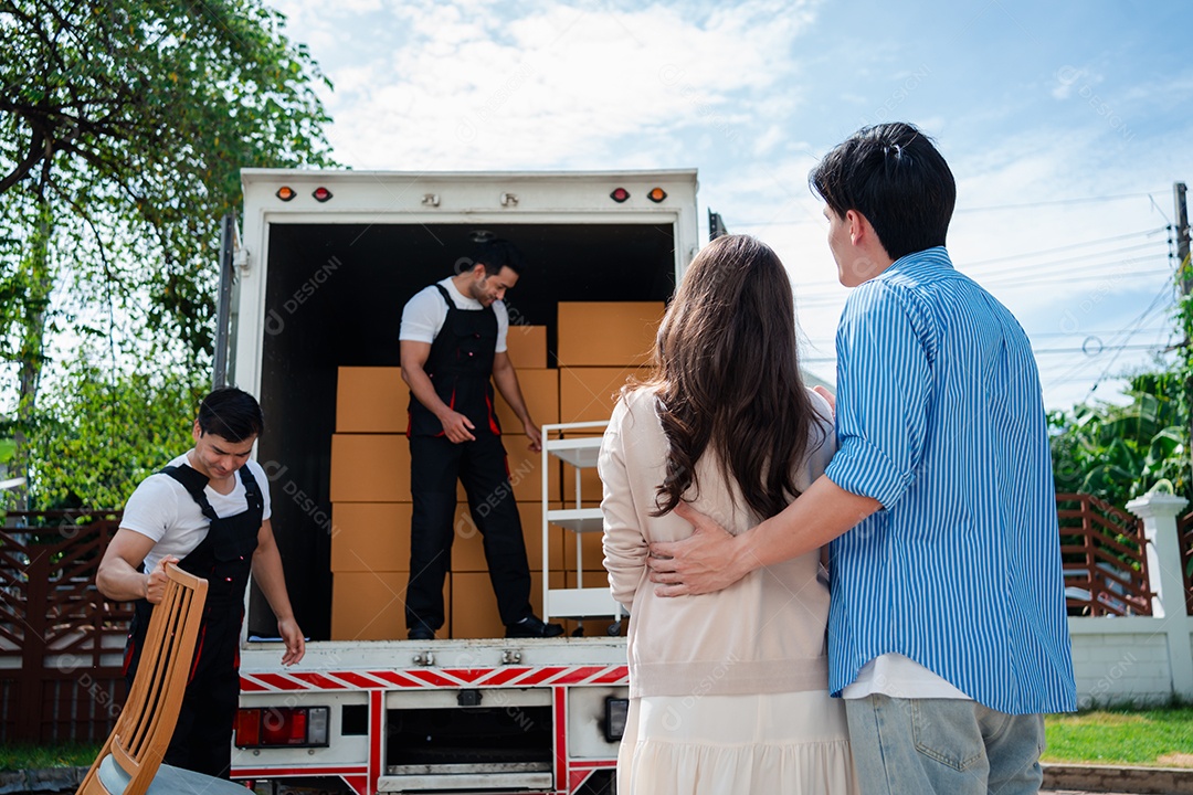 Verificação de casal asiático ao descarregar caixas e móveis de uma caminhonete para uma nova casa