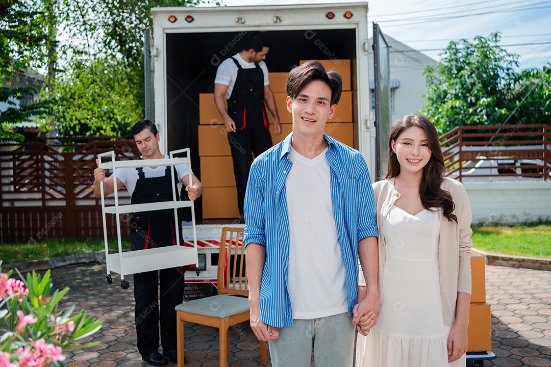 Verificação de casal asiático ao descarregar caixas e móveis de uma caminhonete para uma nova casa