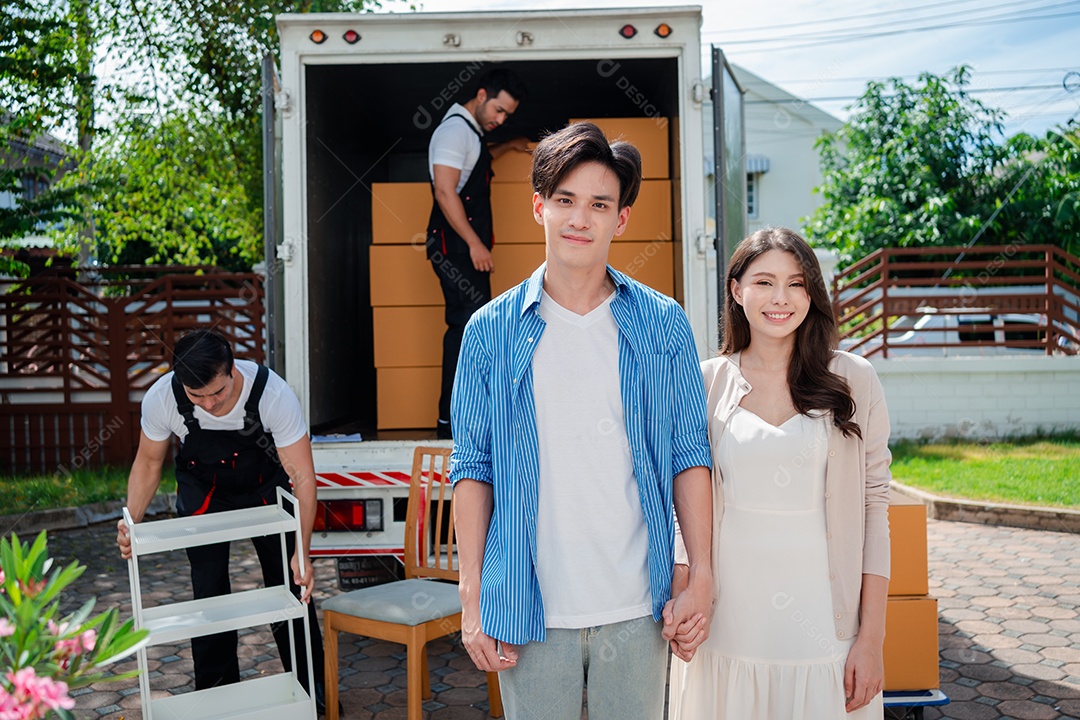 Verificação de casal asiático ao descarregar caixas e móveis de uma caminhonete para uma nova casa