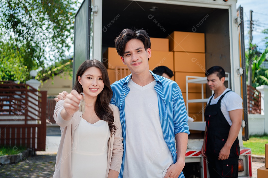 Verificação de casal asiático ao descarregar caixas e móveis de uma caminhonete para uma nova casa