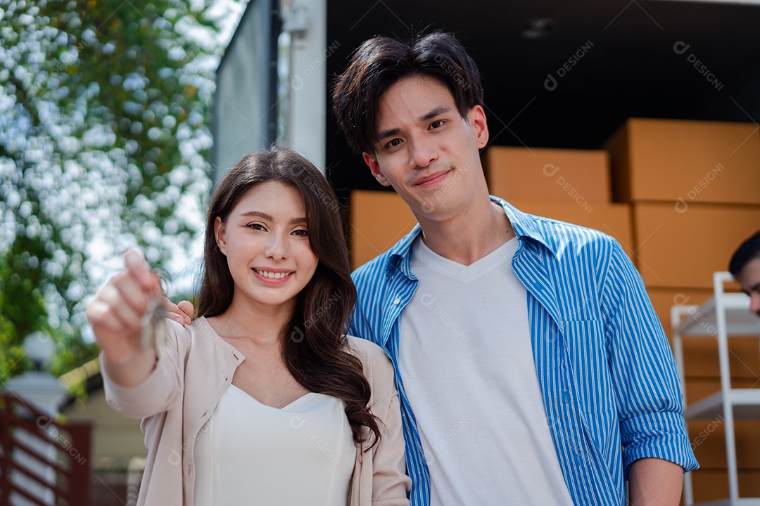 Verificação de casal asiático ao descarregar caixas e móveis de uma caminhonete para uma nova casa